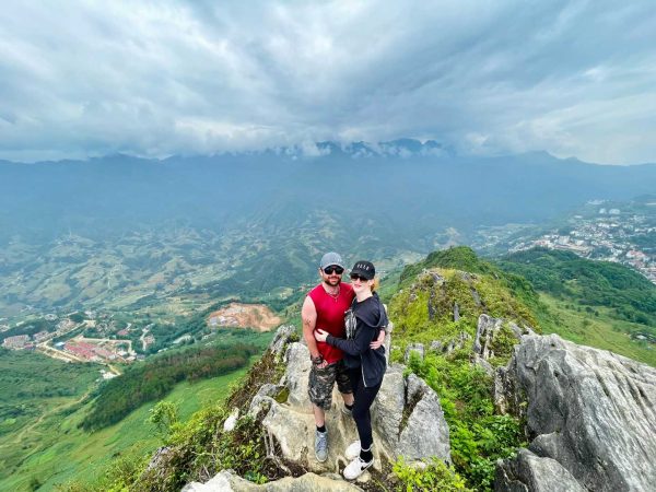 Guest standing on a mountain, photographing the valley and Sapa town below