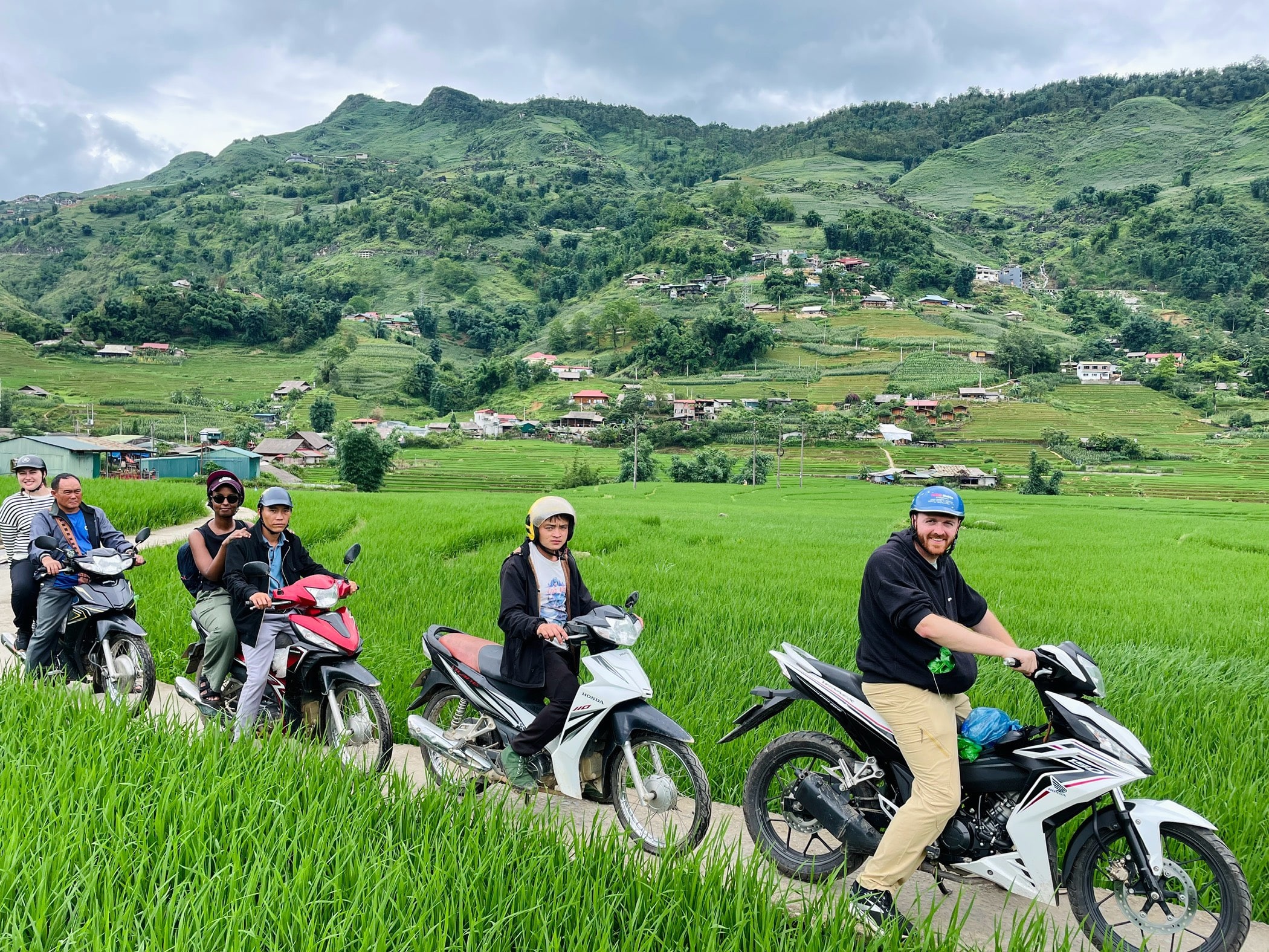 Tour guide and guest riding motorbike through the rice fields on the Sapa Odyssey Tour